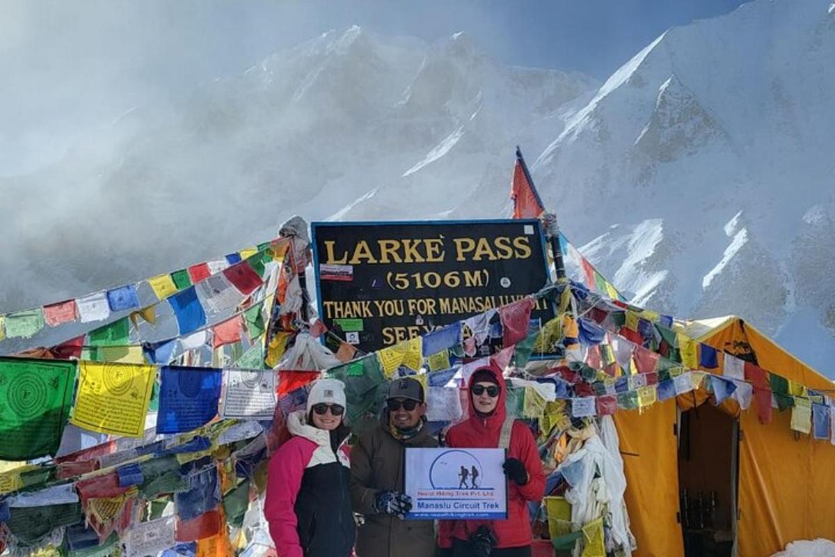 two people standing in front of a sign with a mountain
