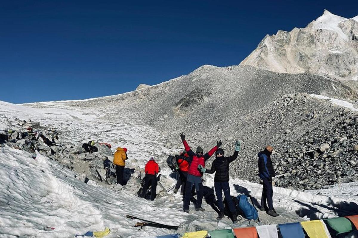a group of people standing on a snow covered mountain