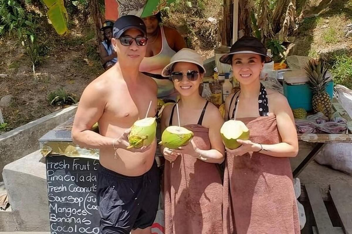 三个裹着毛巾的女人手里拿着椰子