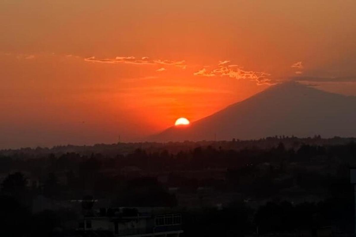 a sunset over a mountain with the sun behind it
