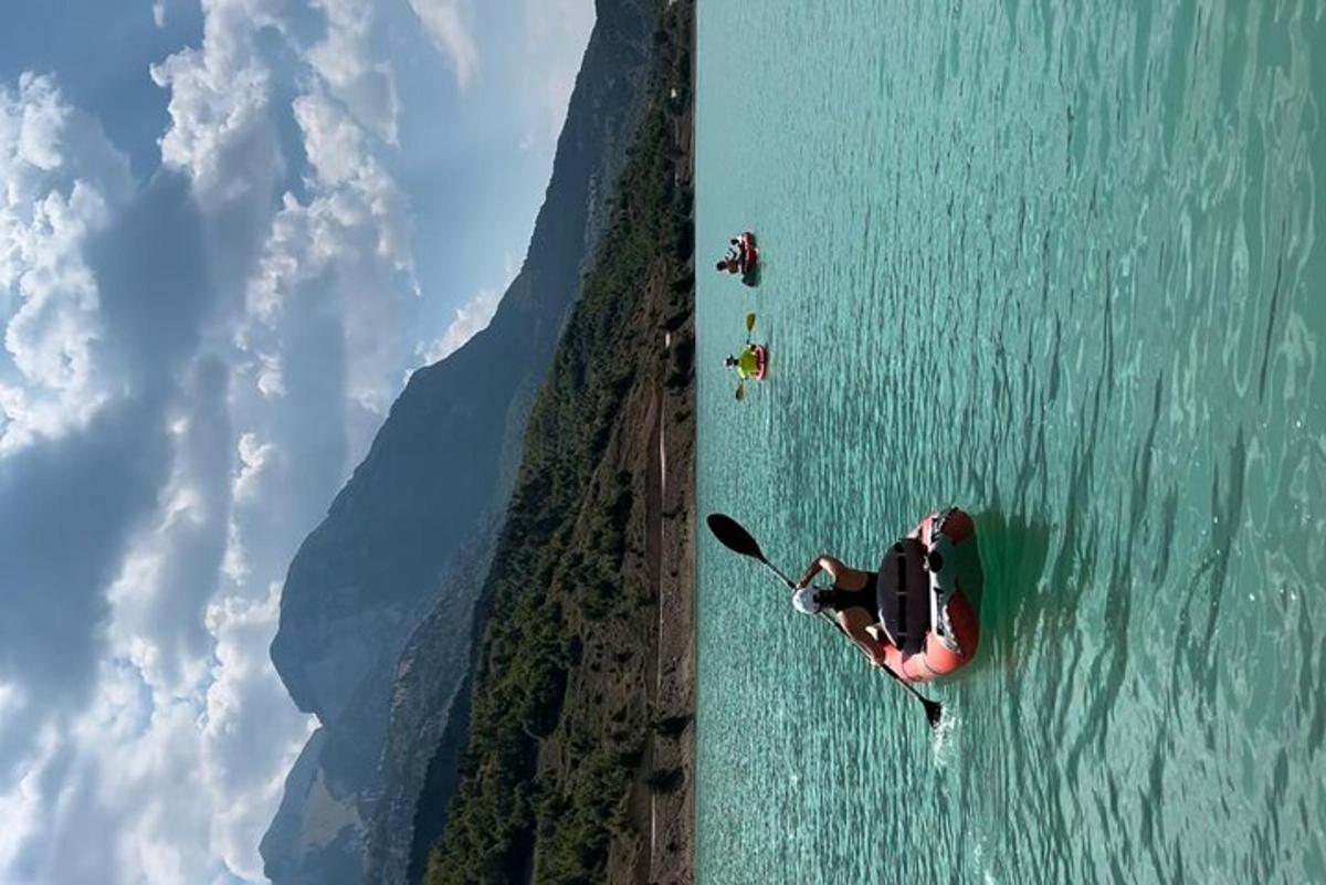 an aerial view of people in a kayak in the water