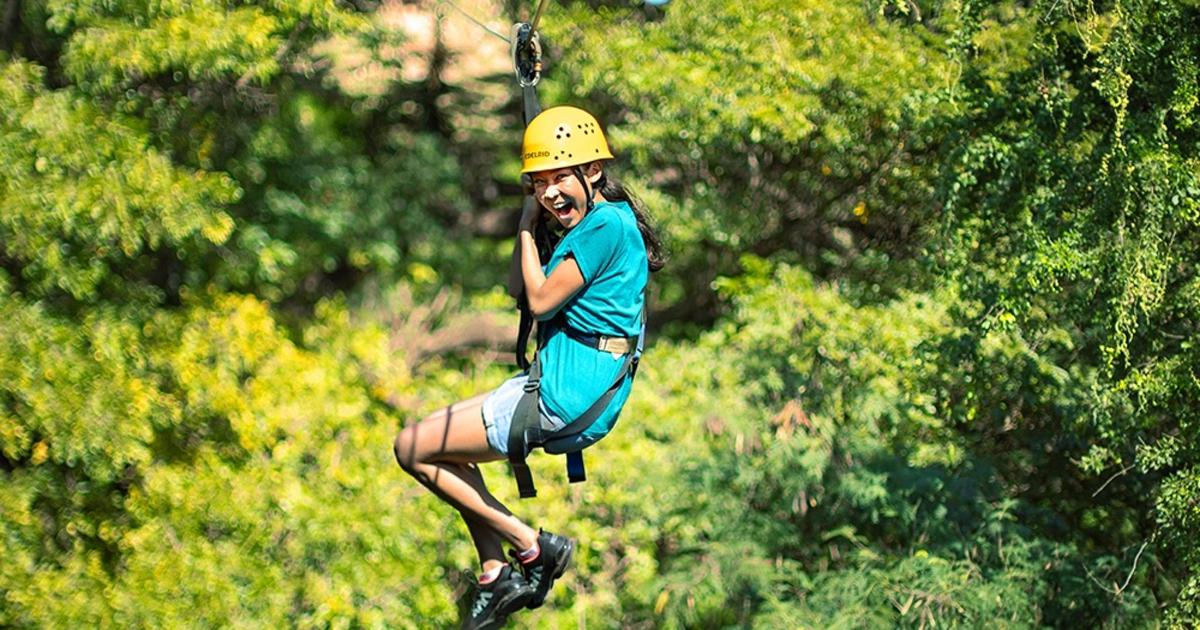 a person in a helmet on a zip line