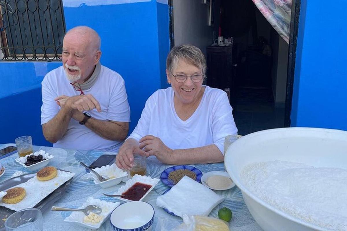 a man and woman sitting at a table with food