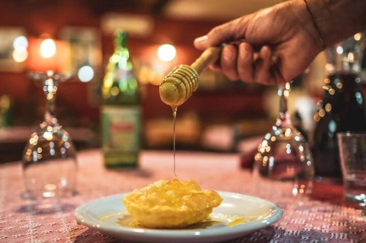 a person drizzling honey onto a plate of food