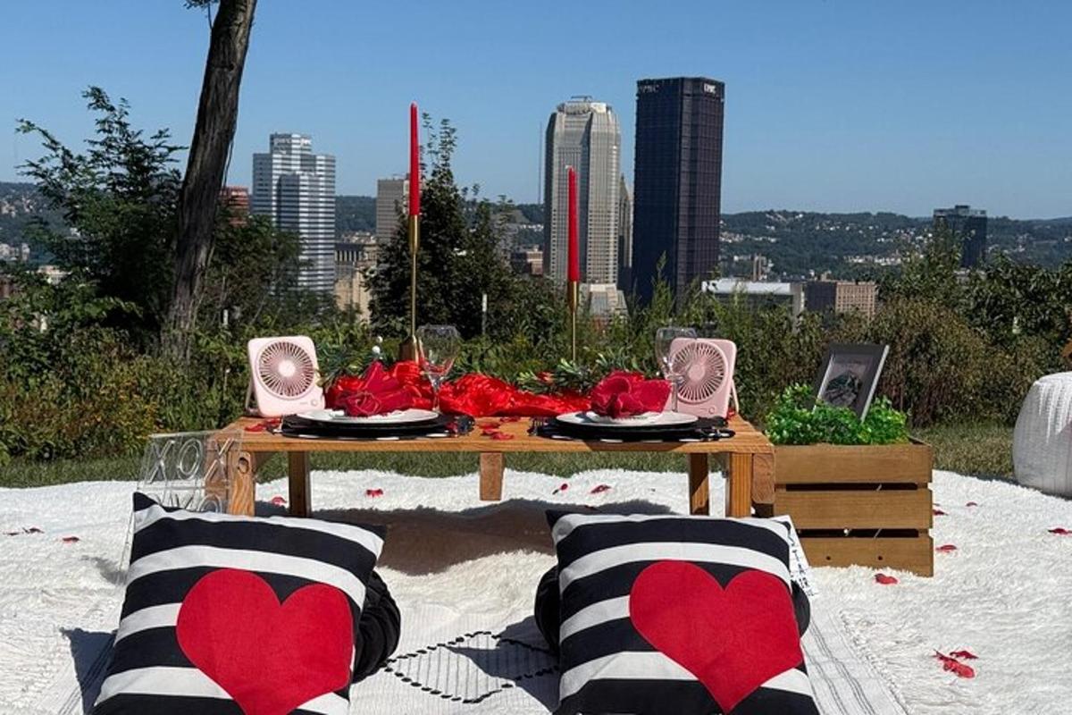 a picnic table with red heart pillows in the sand