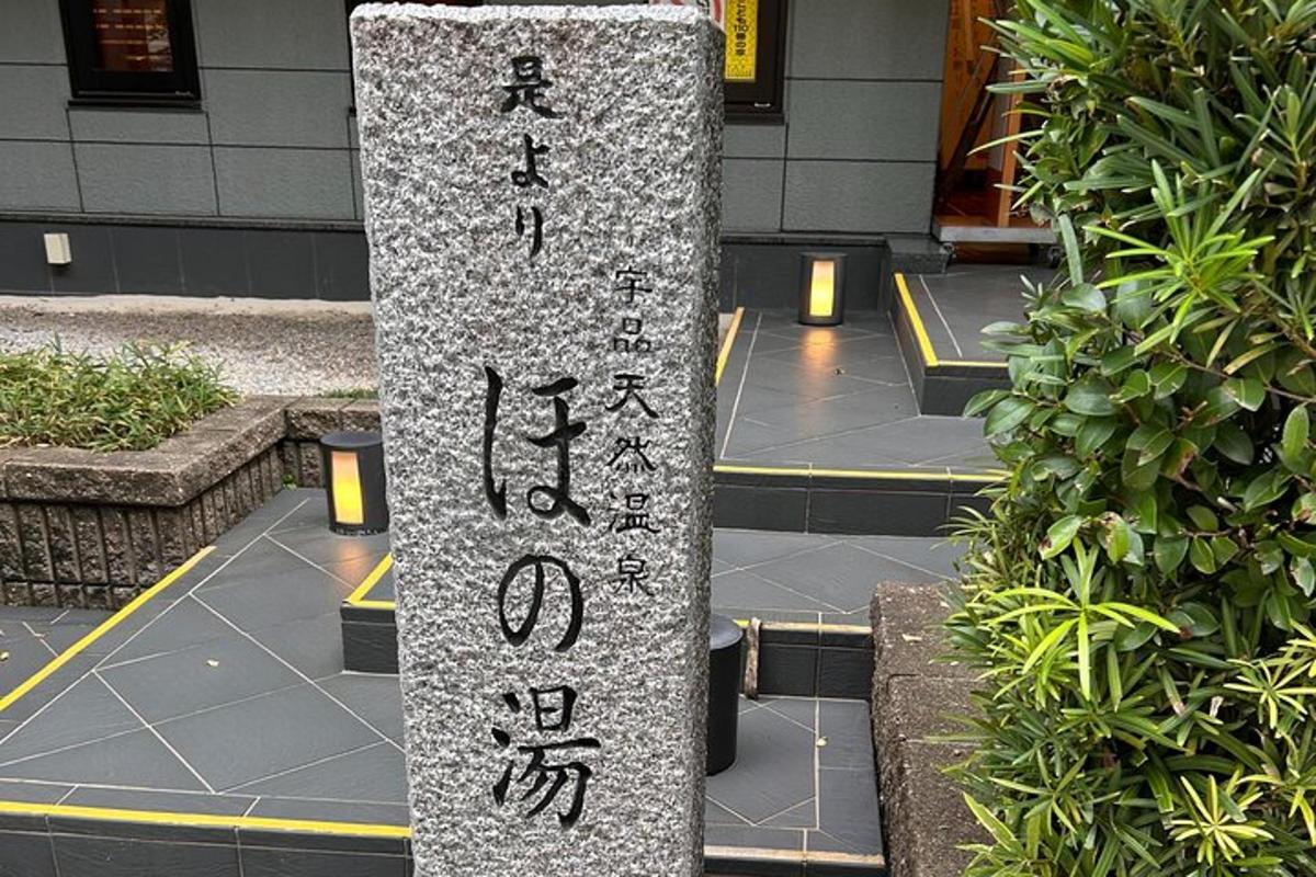 a stone pillar with writing on it in front of a building
