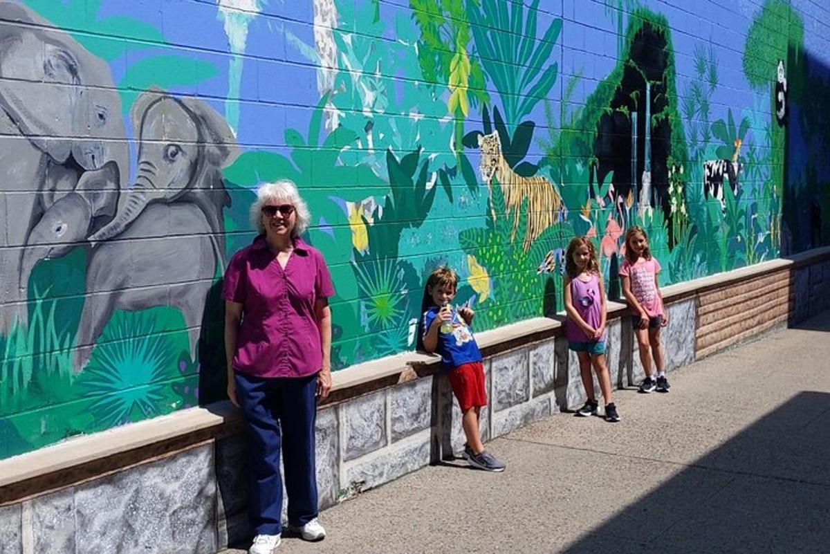 a group of children standing in front of a mural