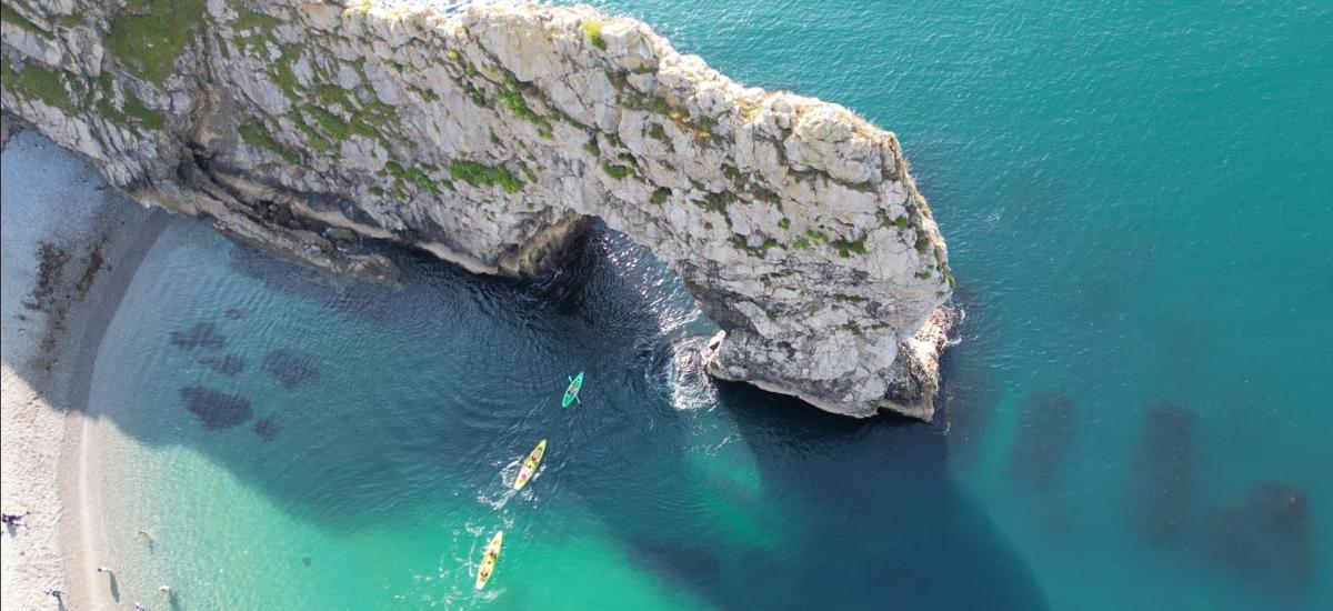 an aerial view of a large rock formation in the ocean