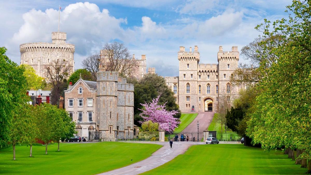 a large castle with a green lawn in front of it