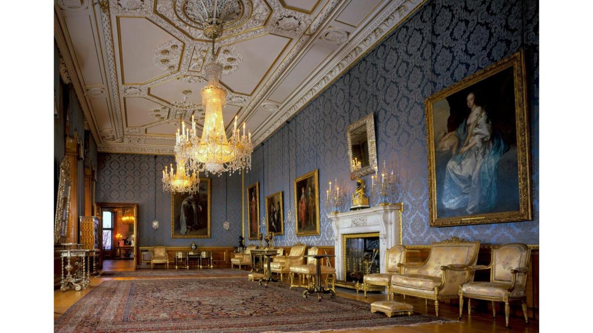 a living room with a chandelier and a room with furniture