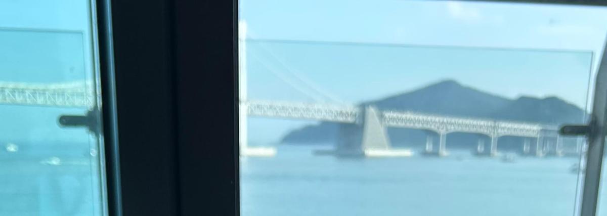 a window with a view of a bridge in the water