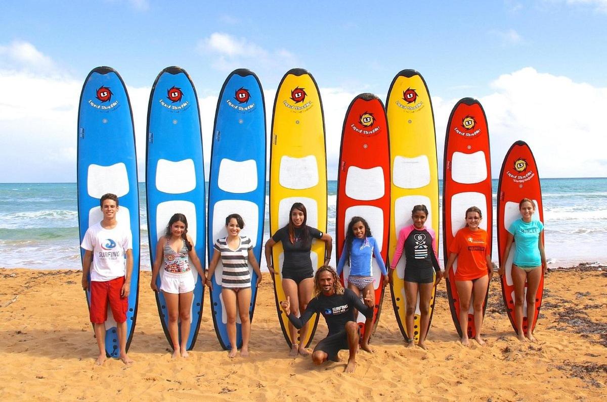 a group of people standing in front of surfboards