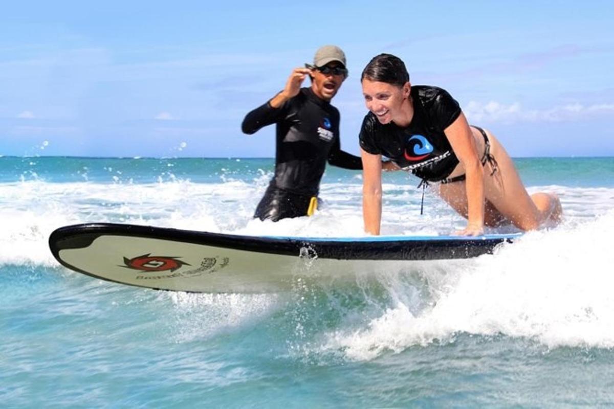 a man taking a picture of a woman on a surfboard in the ocean