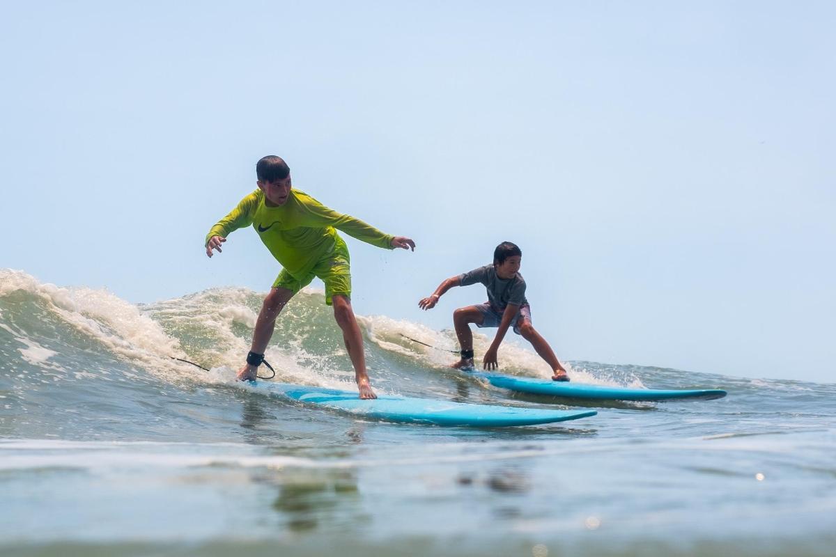 two men riding a wave on surfboards in the ocean