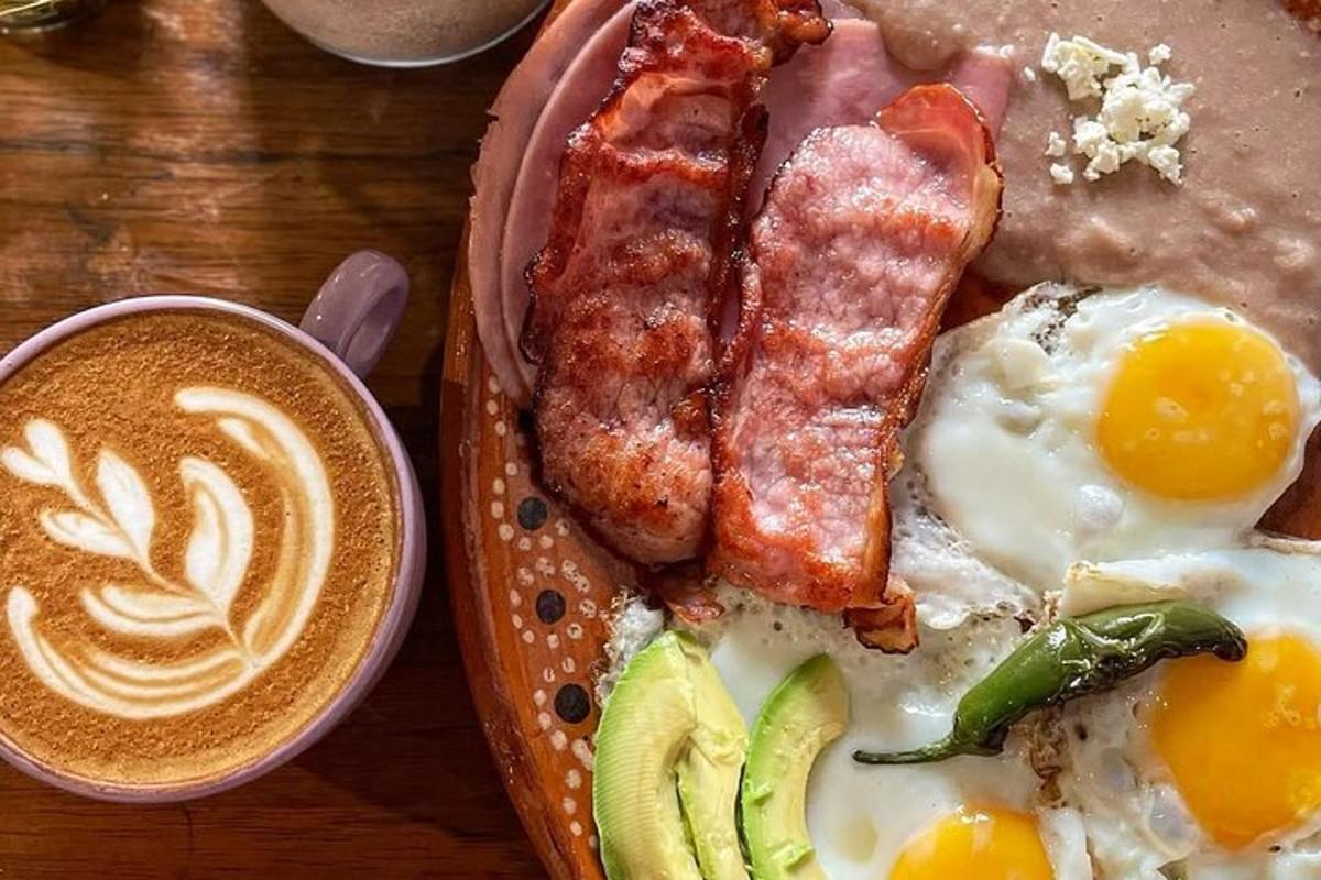 a plate of breakfast food with eggs bacon and a cup of coffee