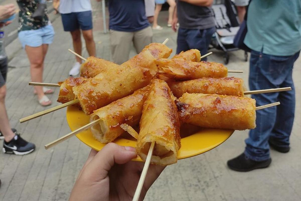 a person holding a plate of food with chop sticks