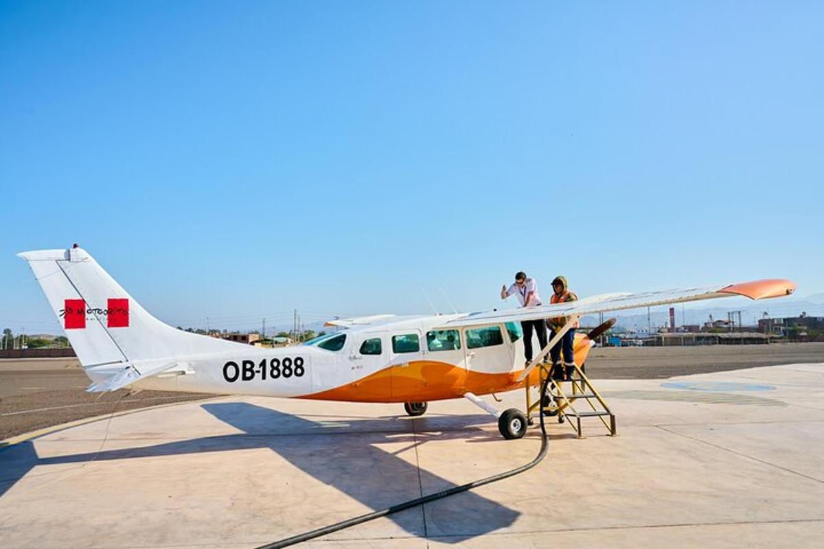 a small plane on a runway with people on it