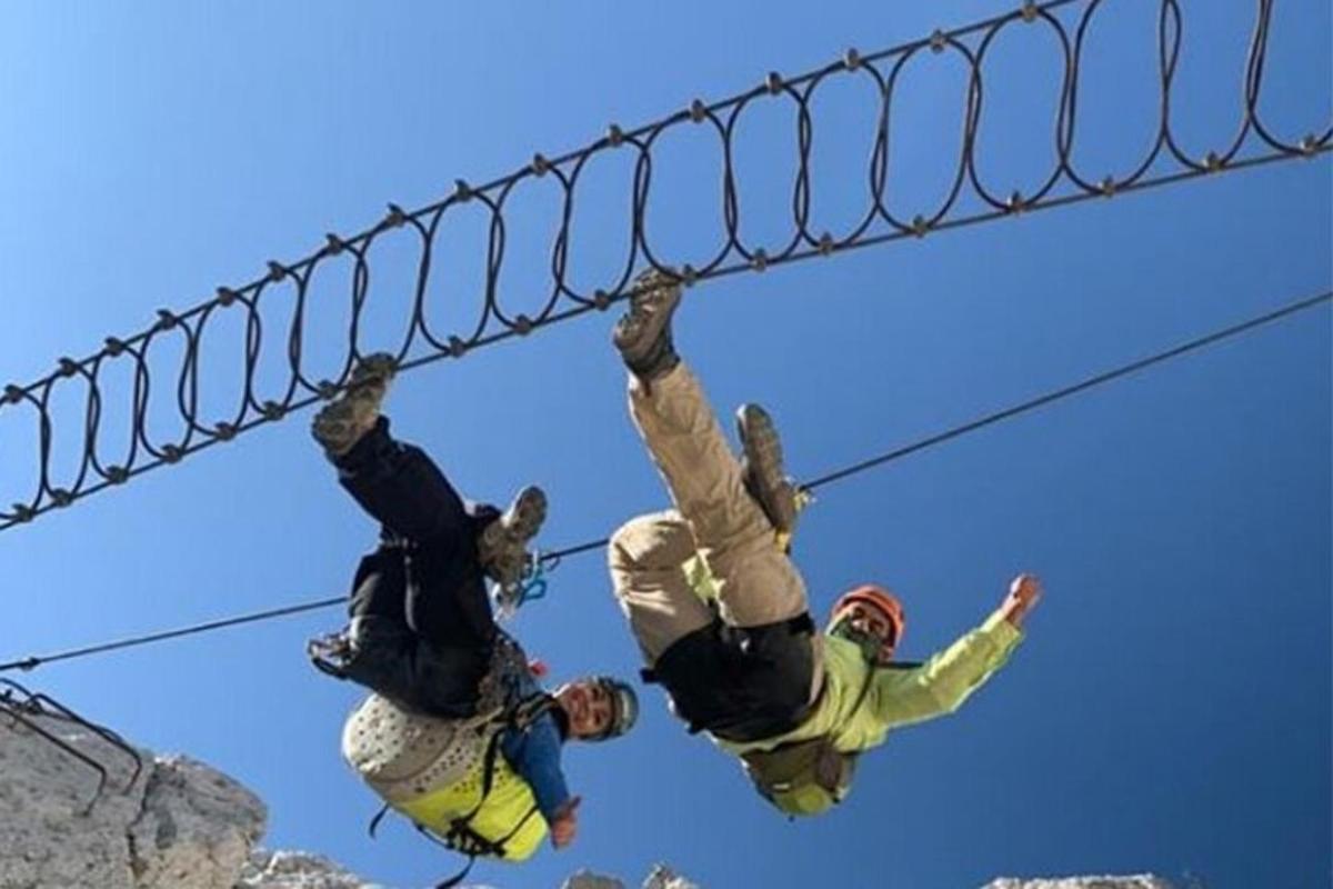 Dos personas están colgadas de una tirolina