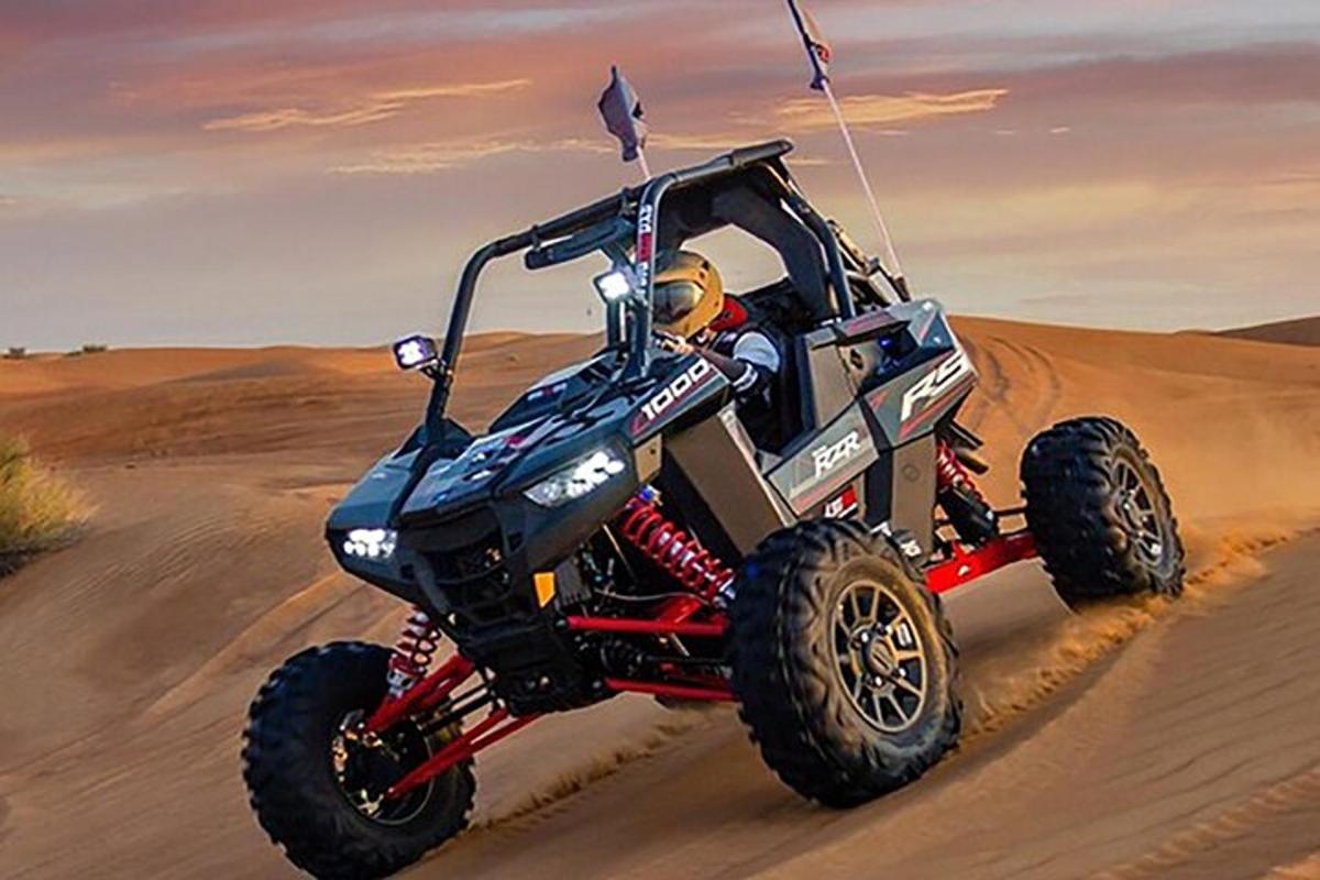 一个人在沙漠中骑着四轮摩托车