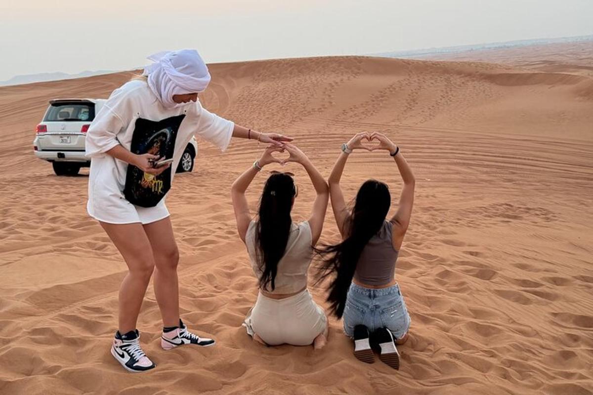 three girls sitting in the desert holding their hands together