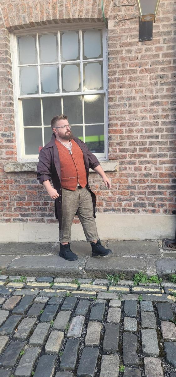 a man standing in front of a brick building