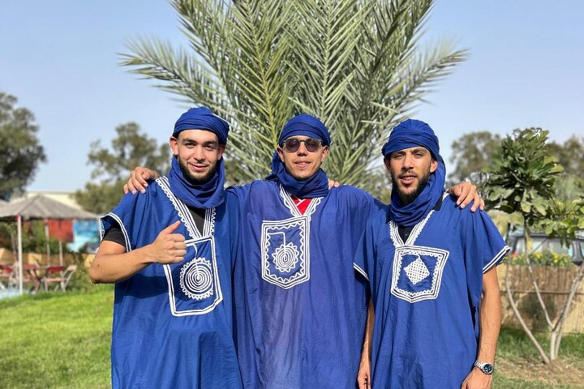 Skupina tří mužů v modrých turbanech pózujících pro fotografii
