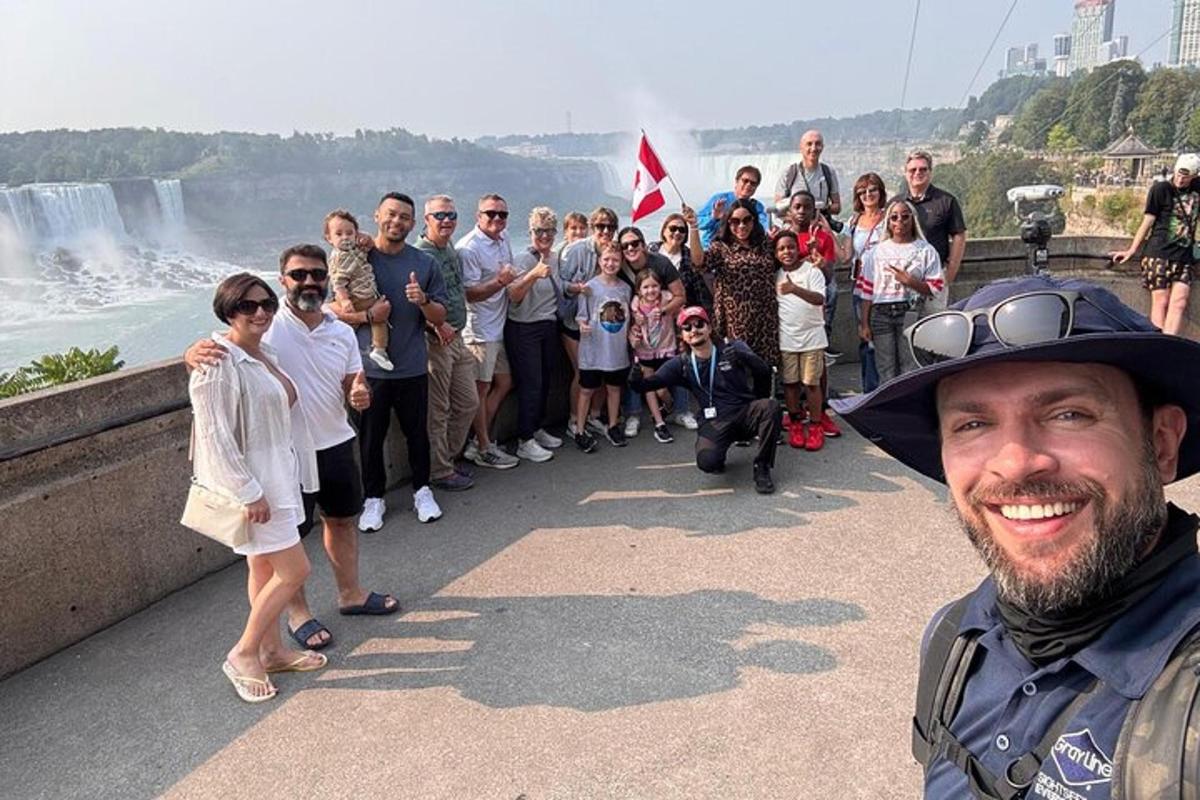 a group of people standing in front of the waterfall