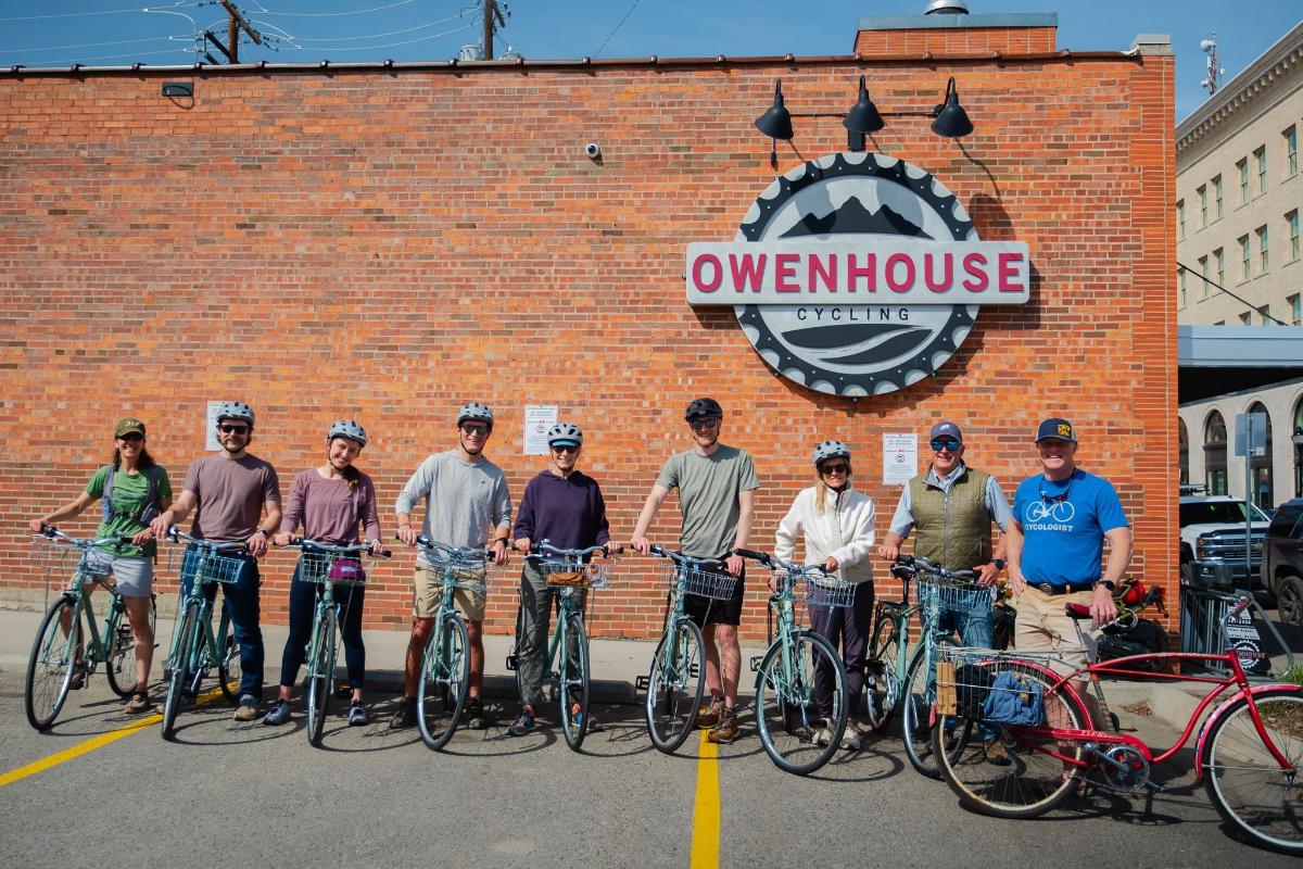 a group of people standing in front of a building with their bikes