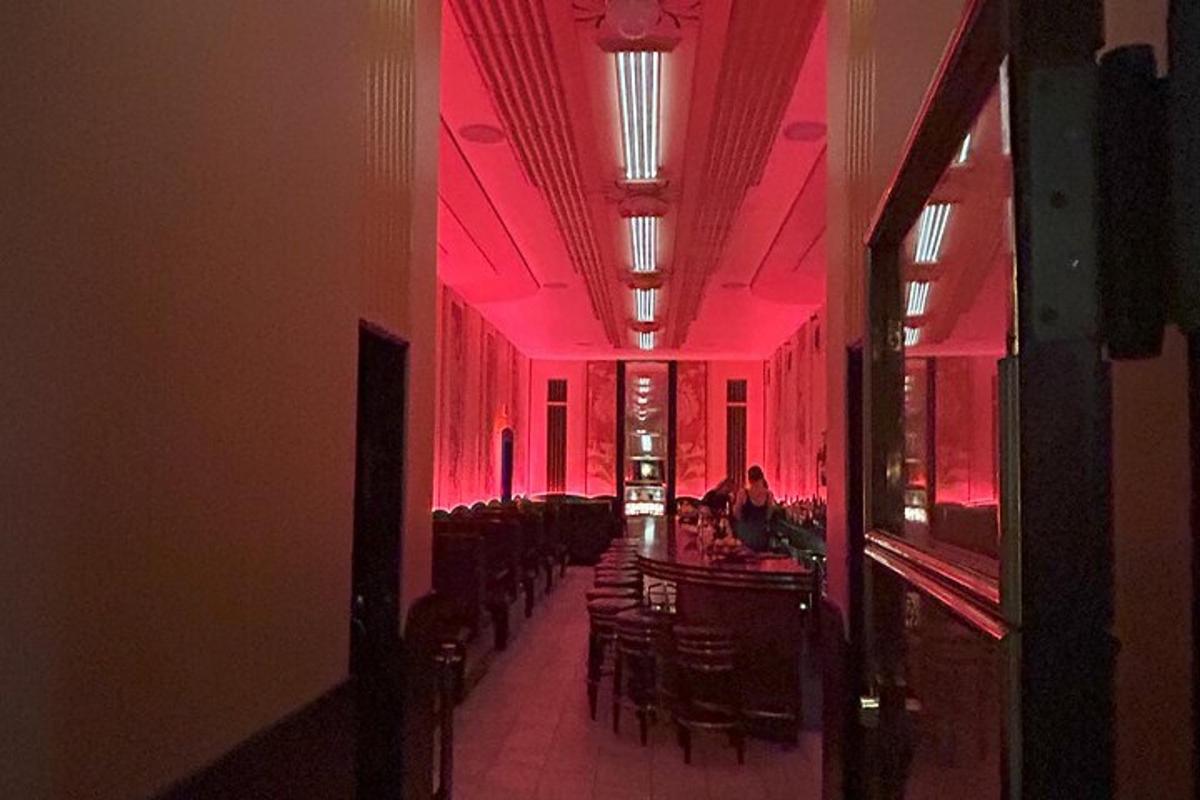 jídelna s růžovým osvětlením, stoly a židlemi