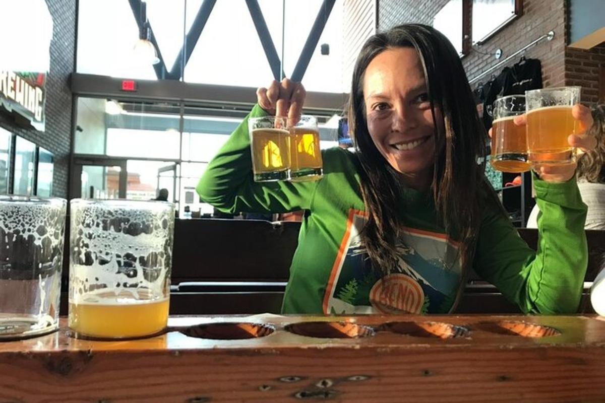 一位女士坐在桌边，手里拿着一杯啤酒