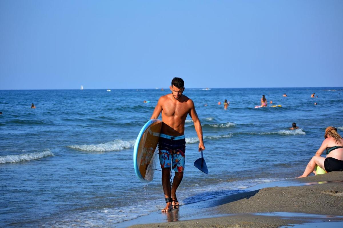 a man walking on the beach with a surfboard