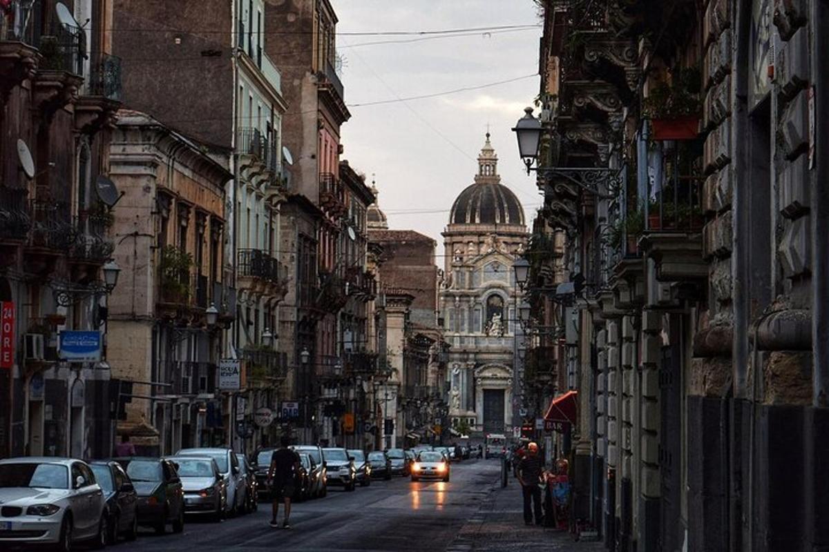 a city street with cars and a cathedral in the distance