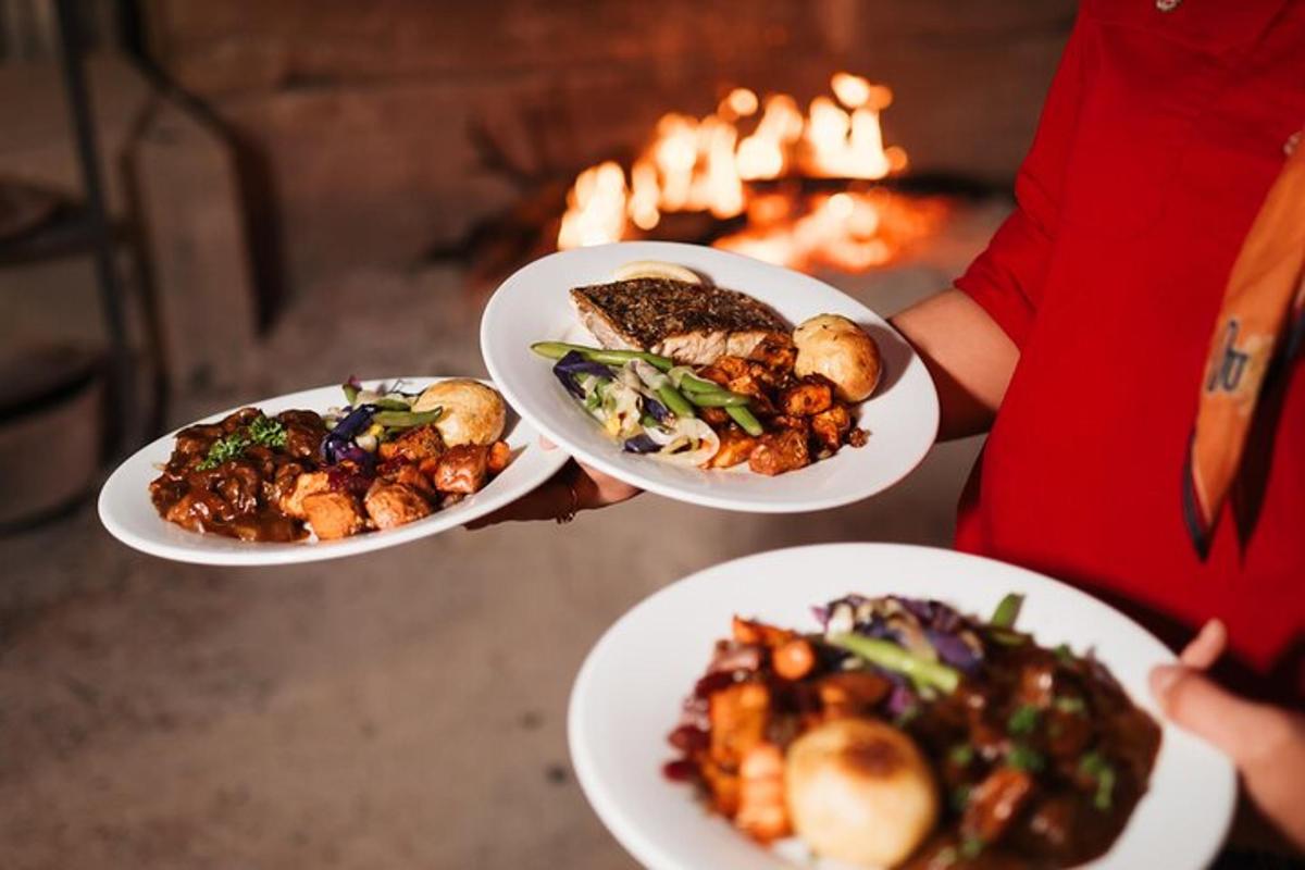 一个人手捧三盘食物站在火堆前