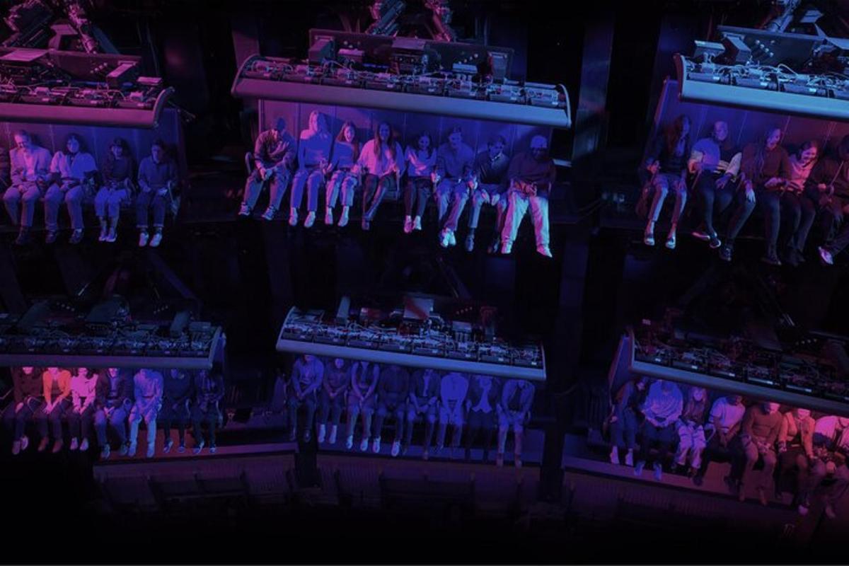 a group of people sitting on a stage with purple lights
