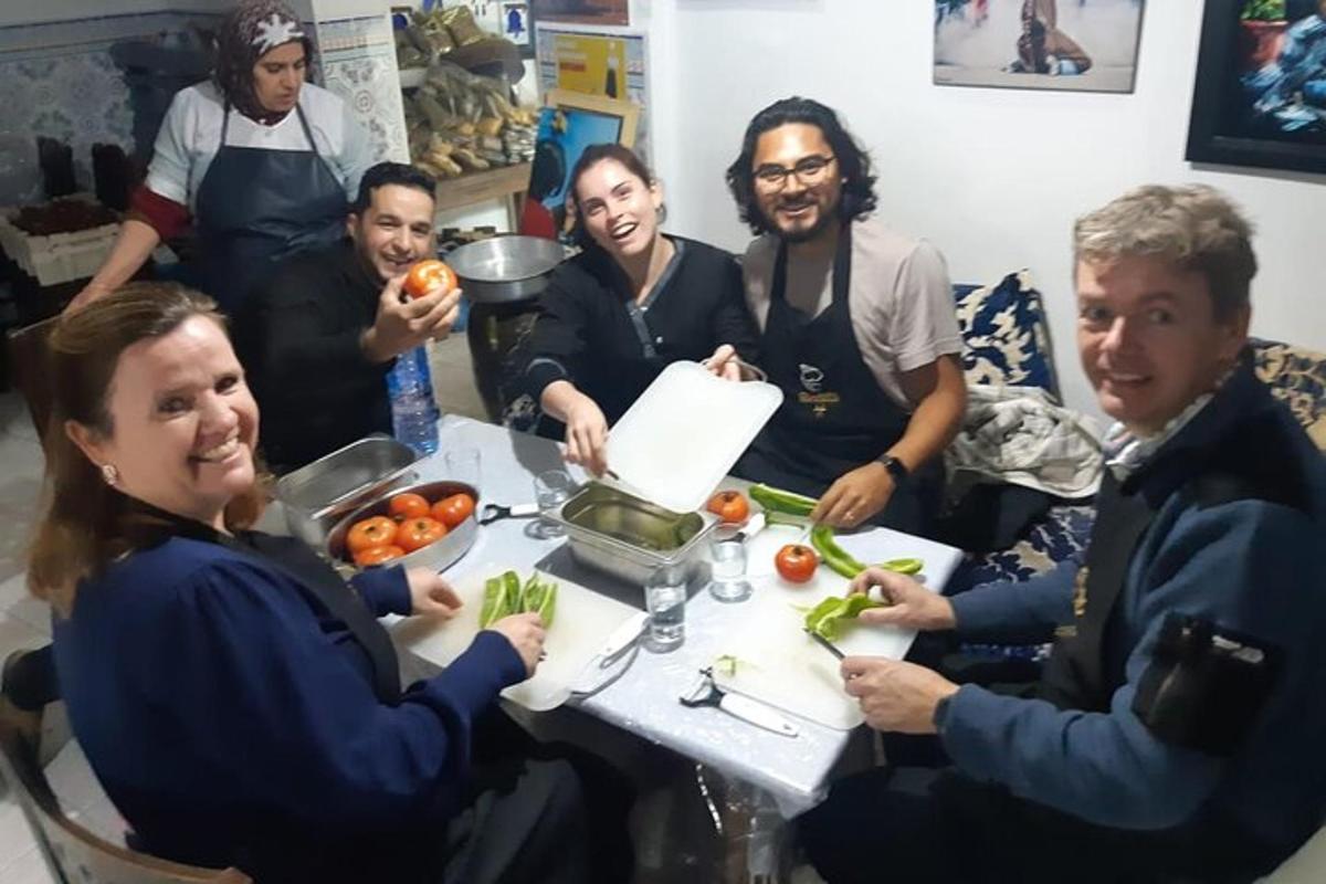 a group of people sitting around a table with vegetables