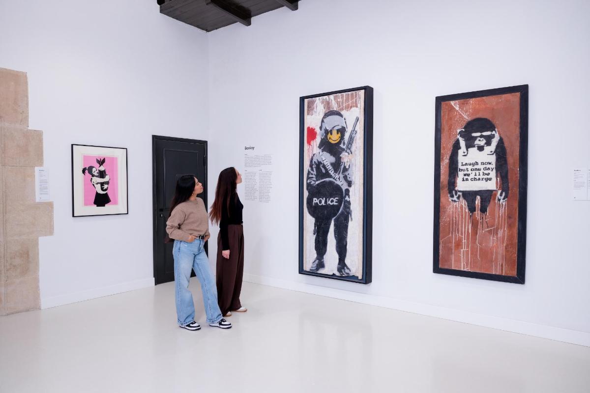 a group of people looking at art on a wall