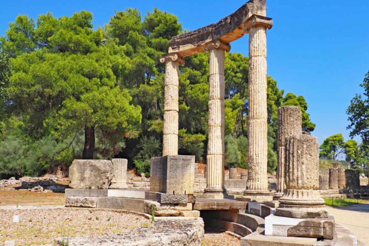 an ancient temple with columns in a park