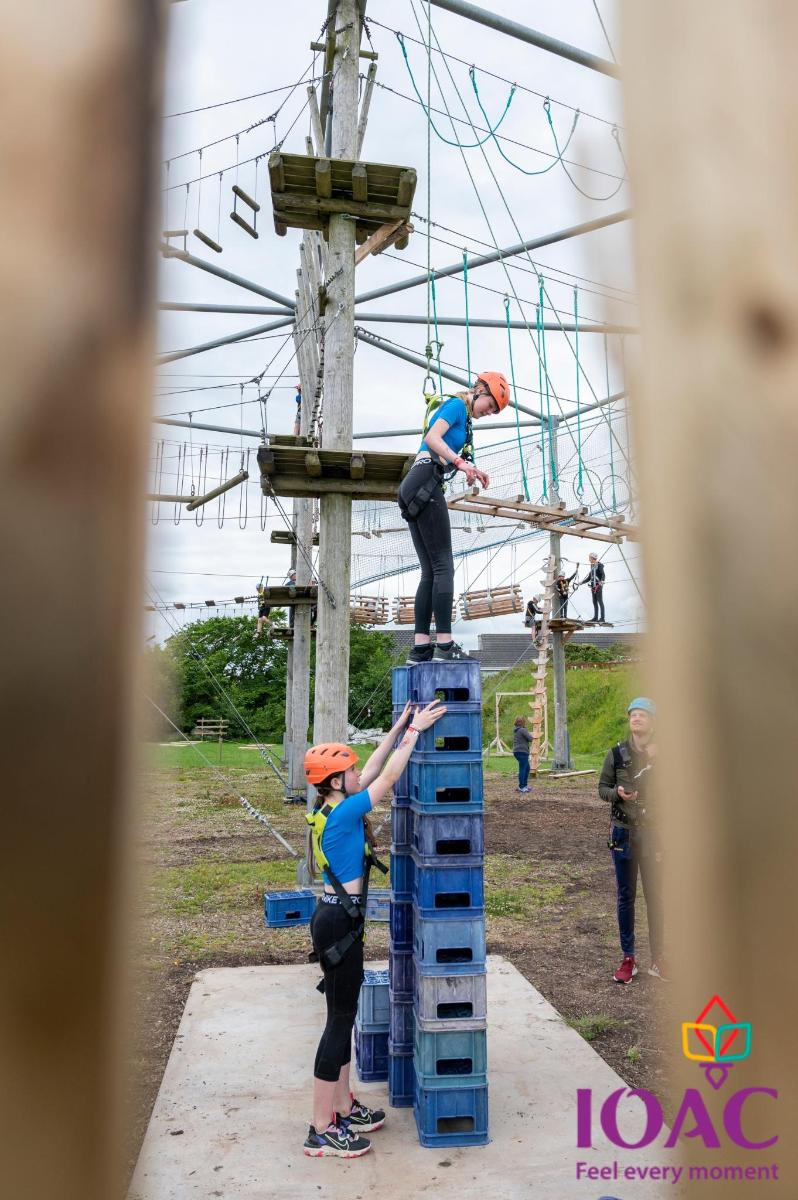 two people standing on top of a stack of blue crates