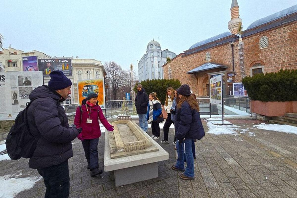 a group of people standing around a stone bench