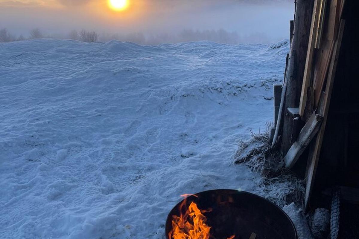 a fire pit in the snow next to a building