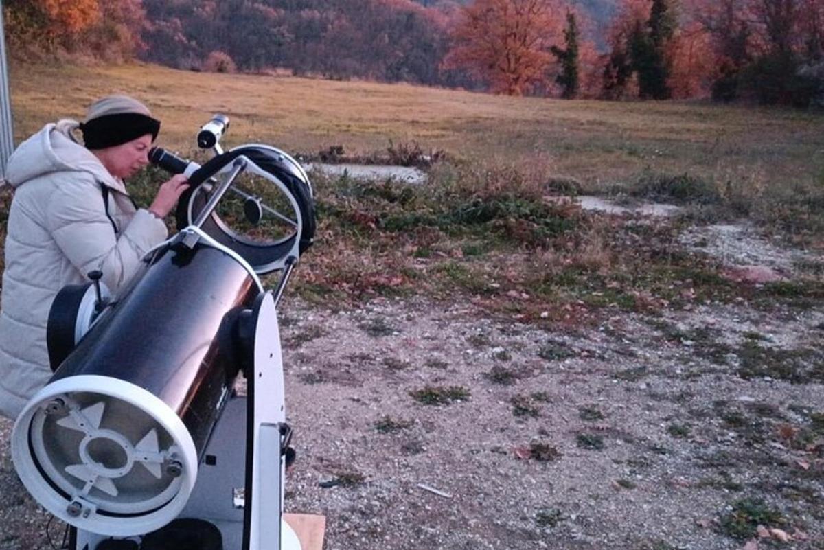 a man is looking into a machine in a field
