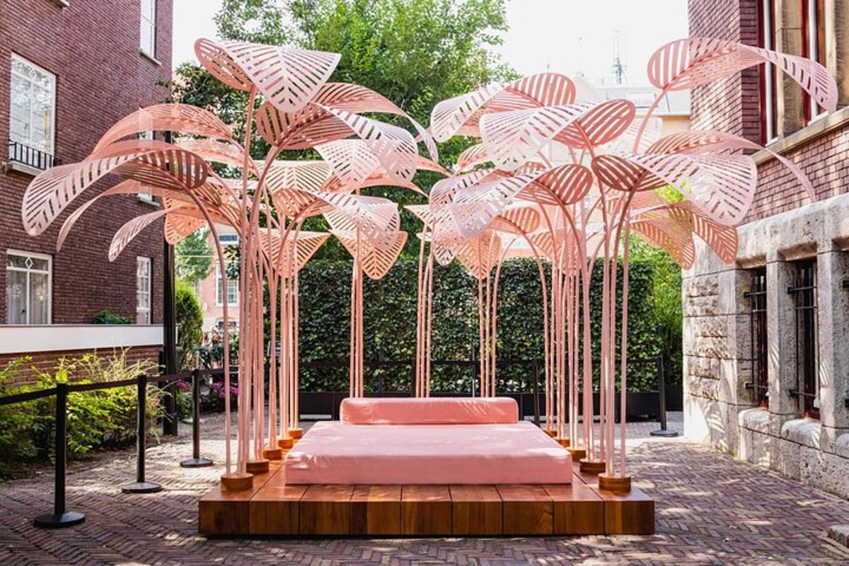 a canopy bed in a courtyard with palm trees