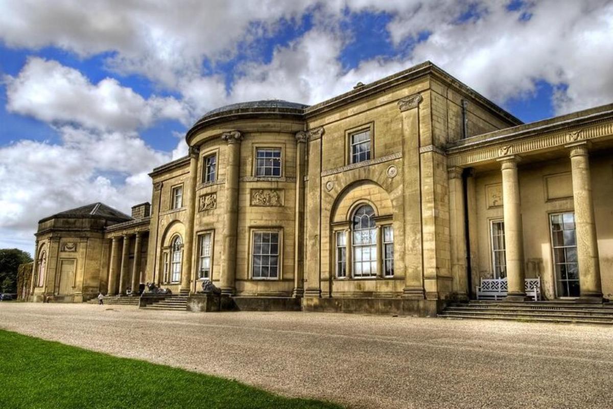 a large stone building with a grass field in front