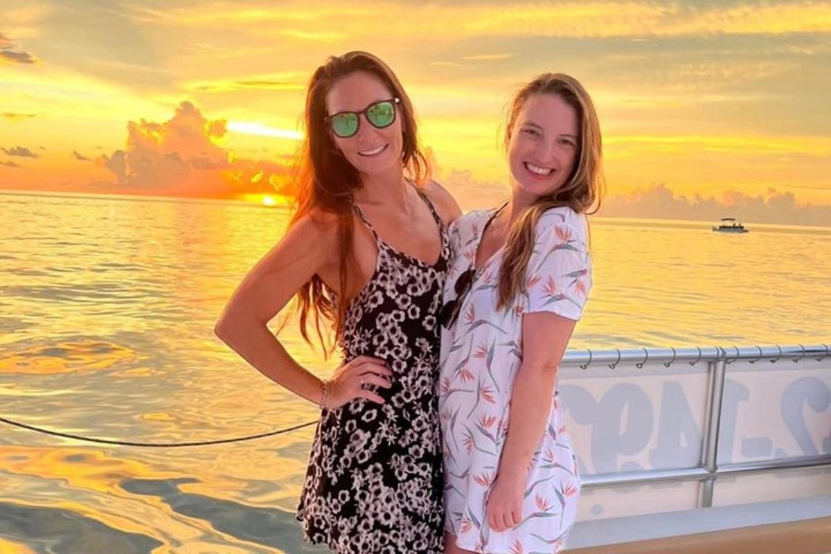 two women standing on a boat in the water