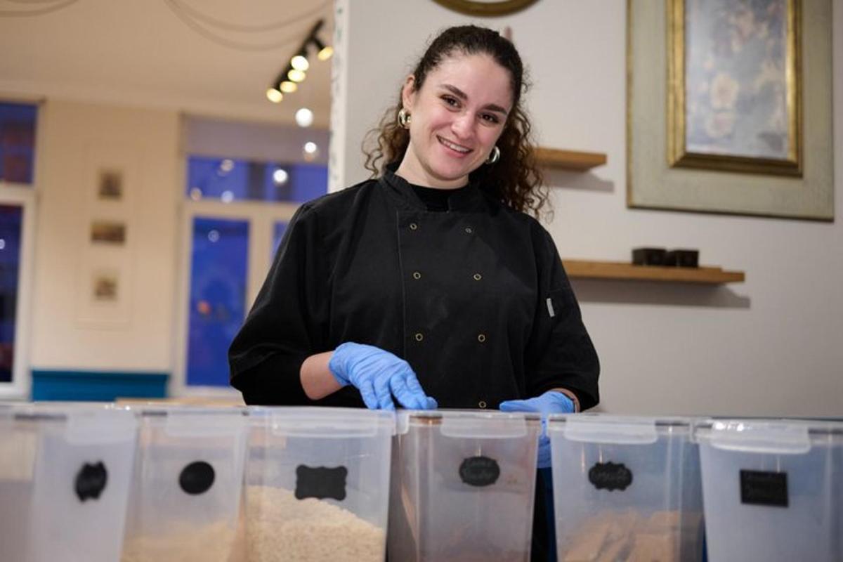 a woman standing behind a counter in a kitchen