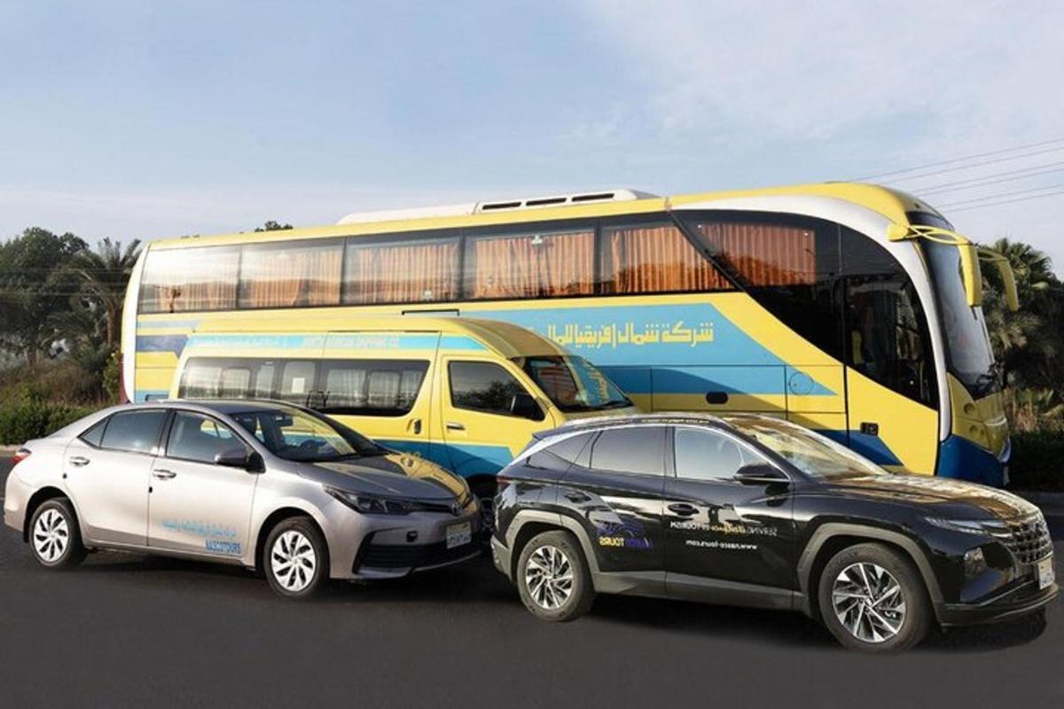 two cars are parked next to a bus