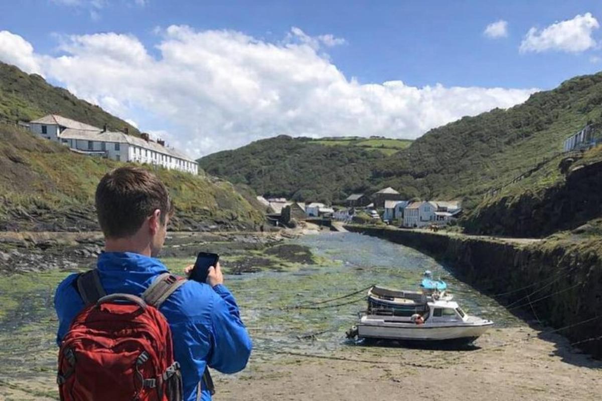 a man taking a picture of a boat in a river