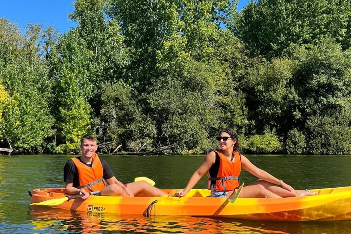 a man and a woman sitting in a yellow kayak in the water