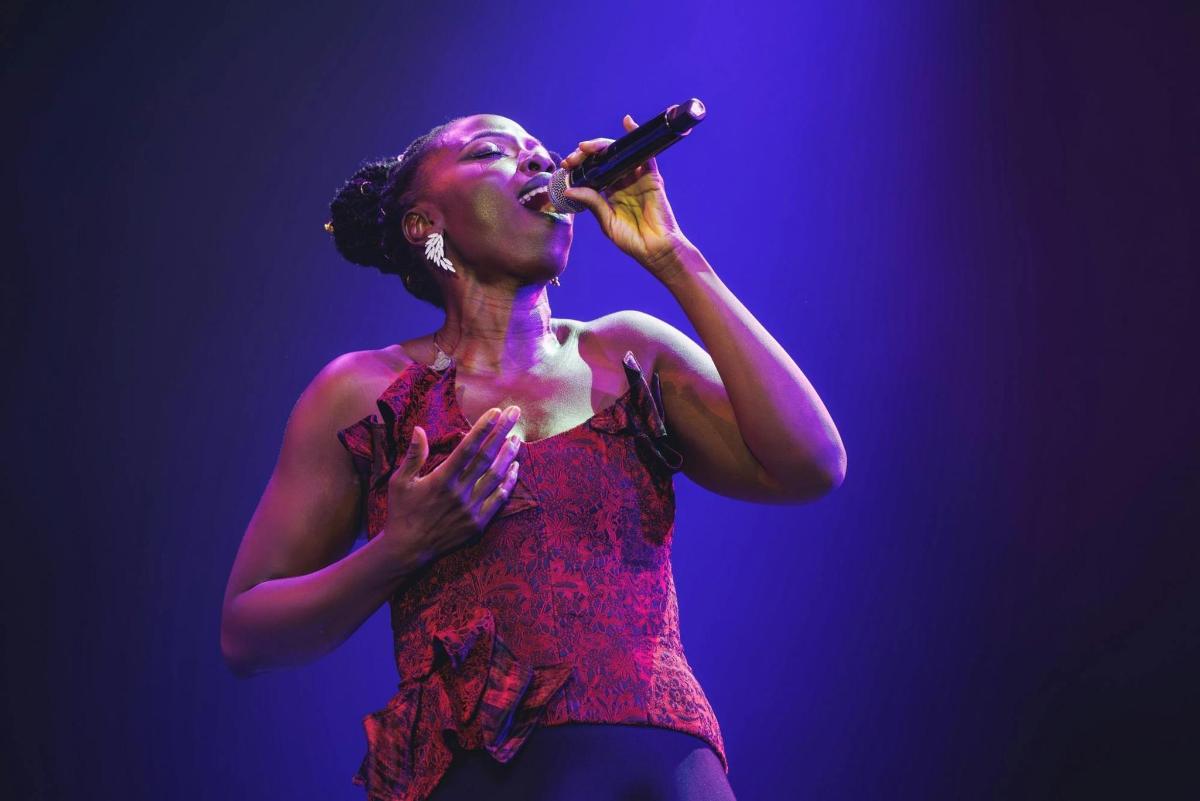 a woman singing into a microphone on a stage