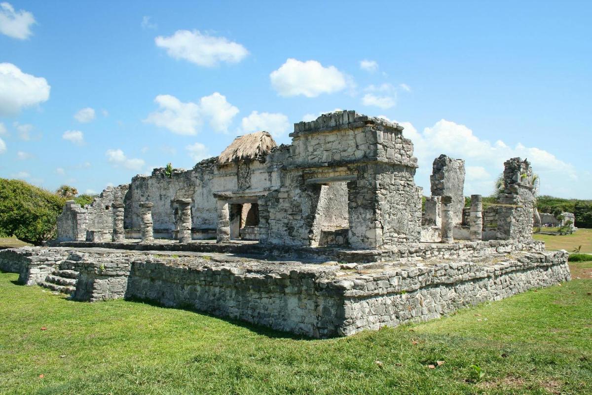 an old stone building in a field of grass